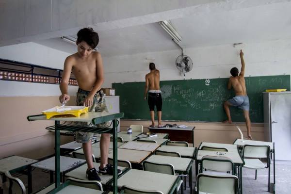Students painting walls and ceilings in a occupied school. Photo: O Mal Educado/Facebook