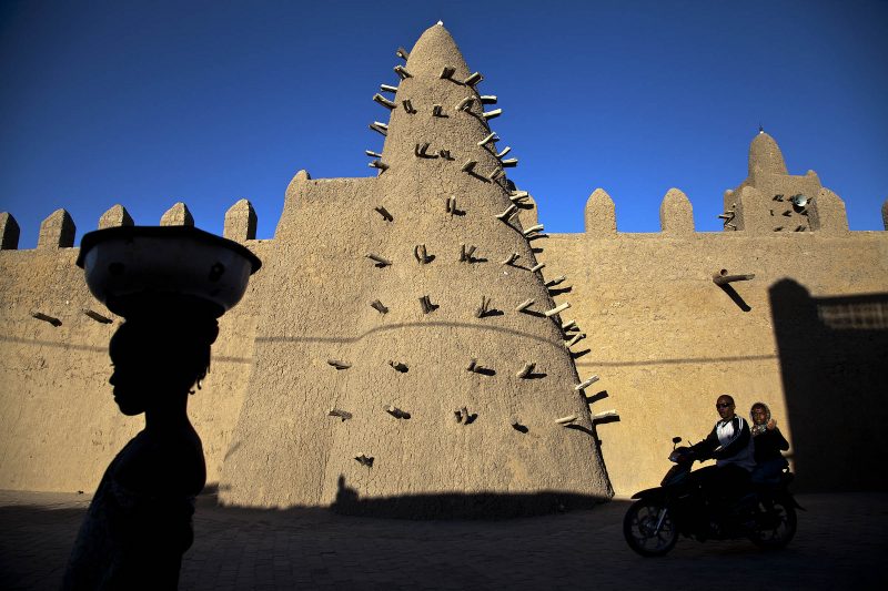 Timbuktu - Residentes pasan cerca de la mezquita Djingarey, una de las tres mezquitas nombradas Patrimonio de la Humanidad por la UNESCO en Timbuktu, al norte de Mali. Foto de MINUSMA/Marco Dormino