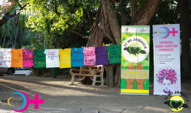 T-shirts and banners emblazoned with anti-gender-based violence messages at the #Beyond16Days Awareness Walk in Hope Gardens, Kingston on December 11, 2016. The event was a partnership between WE-Change, FiWiJamaica and Mary Seacole Hall's Clothesline Project at the University of the West Indies' Mona Campus. Photo by PRIDEja Magazine, used with permission. 