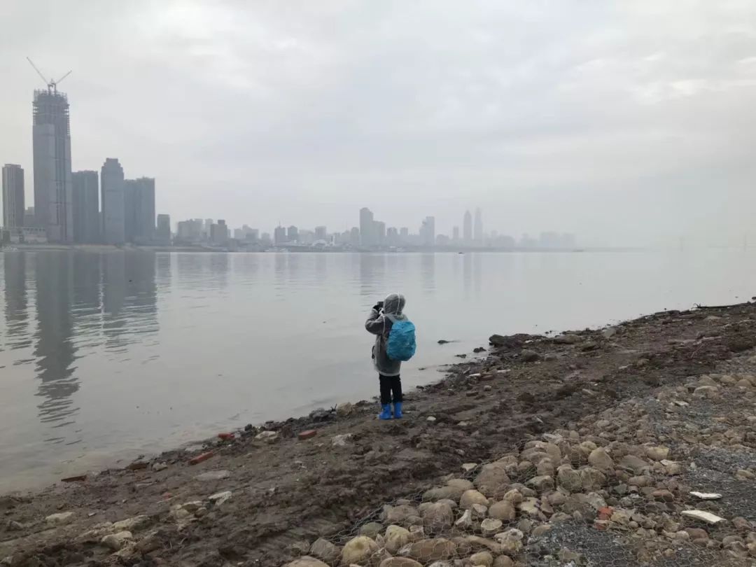 une personne prend des photos des gratte-ciels sur l'autre rive à Wuhan