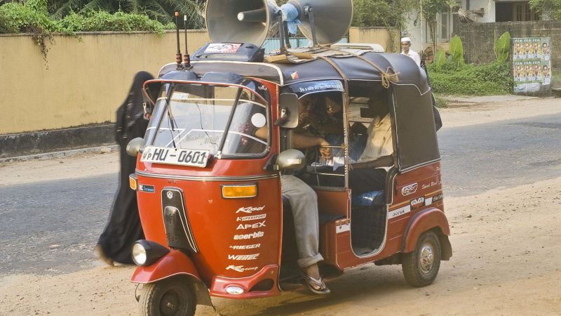 Un tuktuk surmonté de hauts-parleurs diffuse des messages électoraux au Sri Lanka.