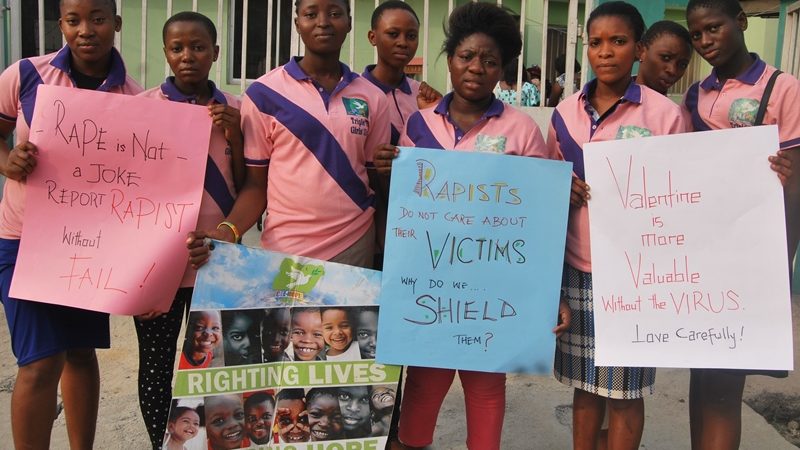 Un groupe de jeunes filles de l'Etat d'Ogun au Nigéria tiennent des pancartes contre le viol lors d'une conférence sur ce thème à Lagos. Elles portent un uniforme rose et bleu.
