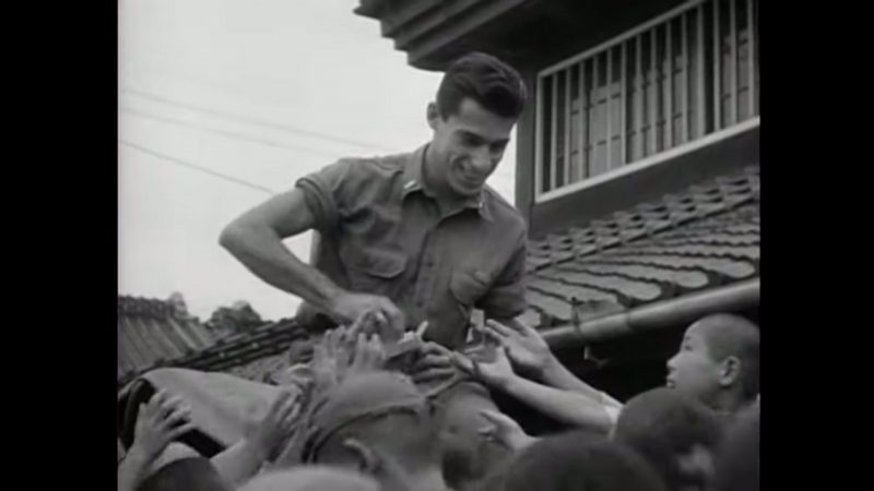Un soldat américain distribue de la nourriture à des enfants japonais pendant l'occupation d'après-guerre.