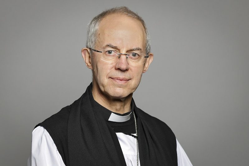 L'archevêque de Canterbury, en soutane. Il porte des lunettes à montures discrètes et a les cheveux gris.