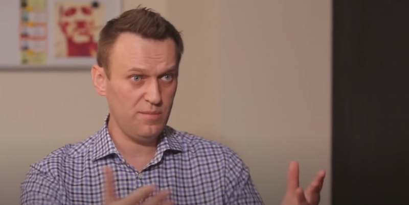 Alexeï Navalny lors de l'interview, en chemise à carreaux. Il semble concentré, le front plissé.