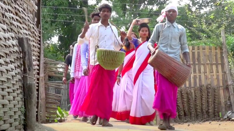 Young girls return from collecting soil from the forest, accompanied by boys playing the dhol. Image via the Record Nepal. Used with permission.