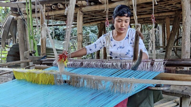 Jonali Pegu from a self help group of women in Major Chapori village of Majuli photographed weaving in her household loom. Image credit: North East Area Affected Development Society (NEADS). Used with permission.
