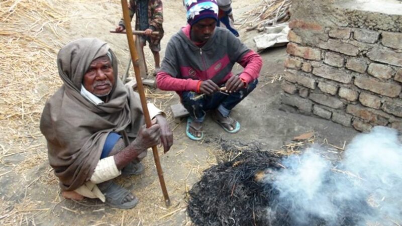 Musahars in Mahottari warm themselves by a fire. Image by the author. Used with permission.