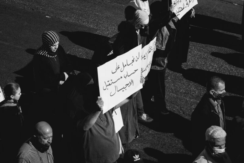 مُحتج يرفع لافتّة تقول، "لن نجامل على حساب مستقبل الأجيال".