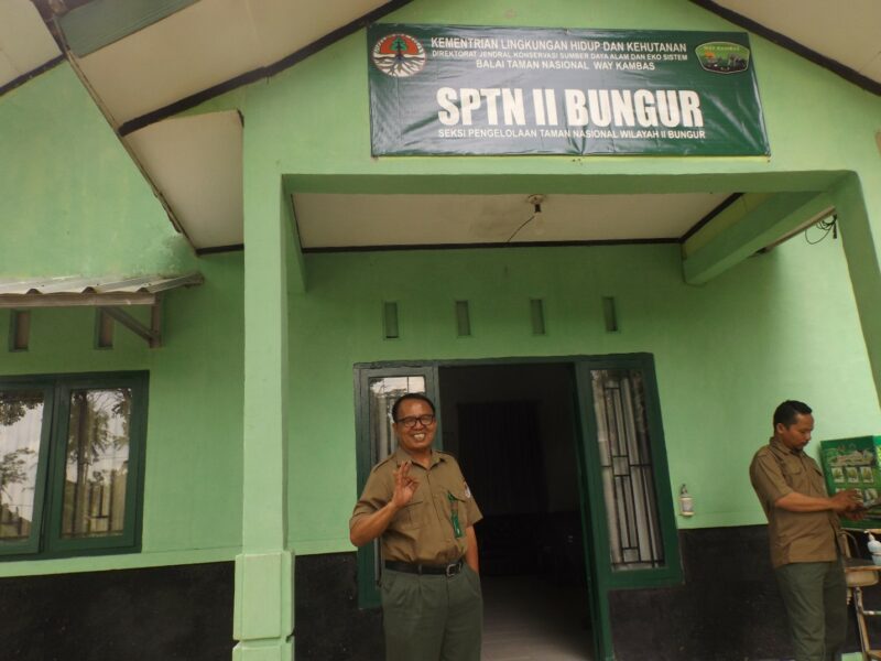 Nazaruddin (wearing glasses) stands outside his ERU office, accompanied by colleague Nurhadi.  Photo by Andi Aisyah Lamboga